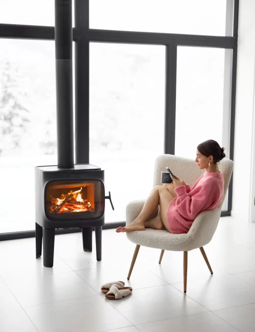 woman-with-cup-chair-by-fireplace-house-nature